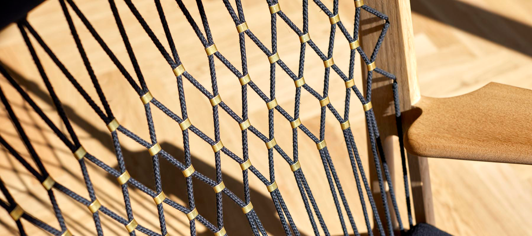 A black netted chair, with gold clasps holding the black netting together