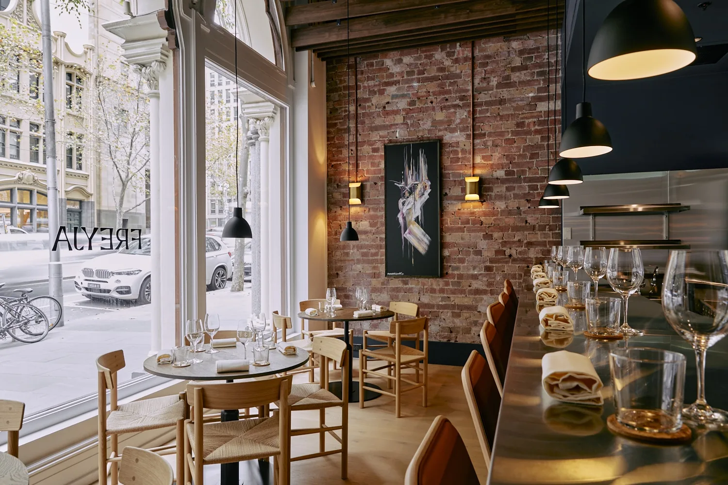A beautiful and classy restaurant / cafe with low dim lights, a brick wall setting and stunning bar