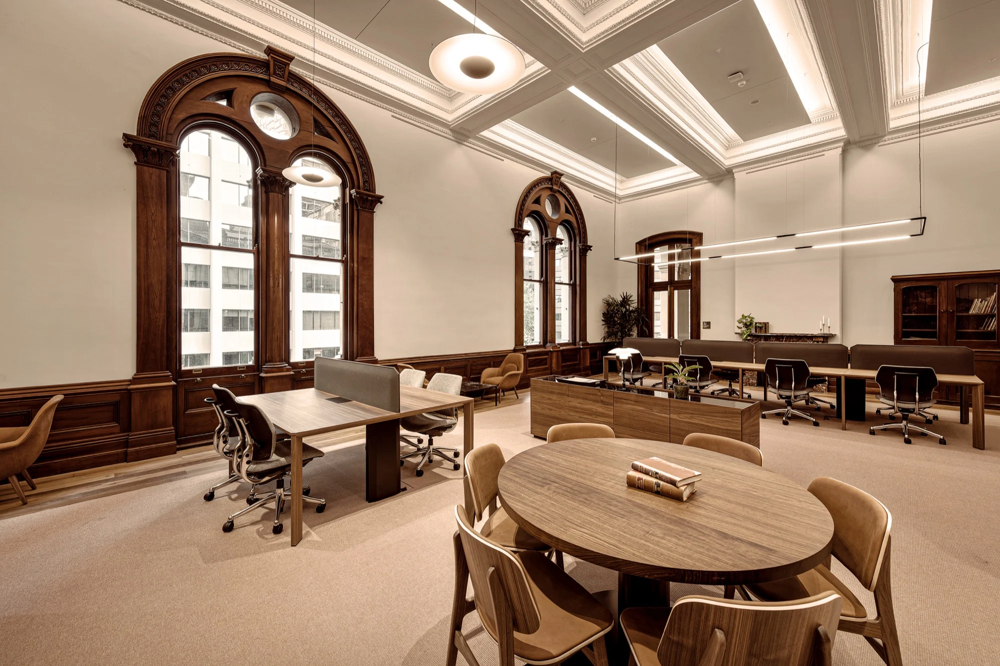 Lounge and shared work tables under the heritage arched windows at The Sandstones Club, Loftus Street, Sydney