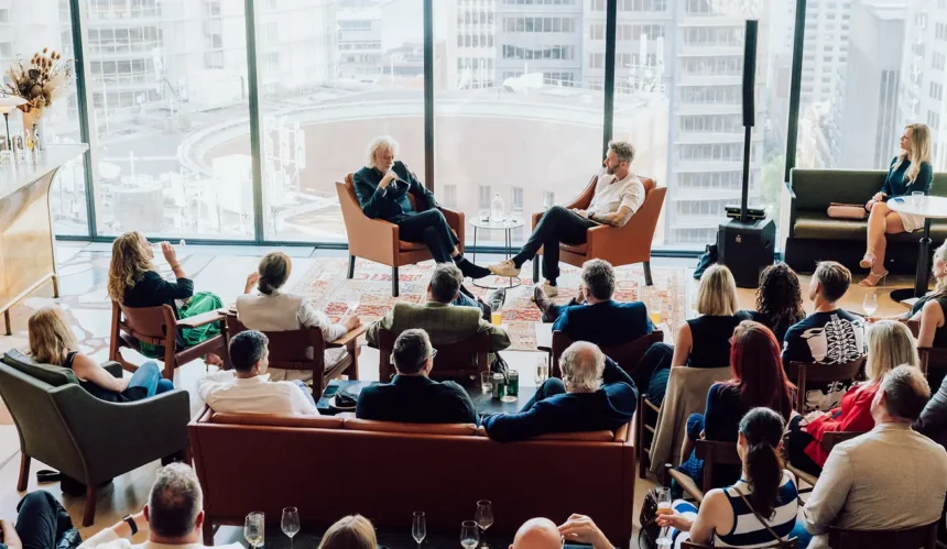 Guests seated in a lounge-style event space with floor-to-ceiling city views