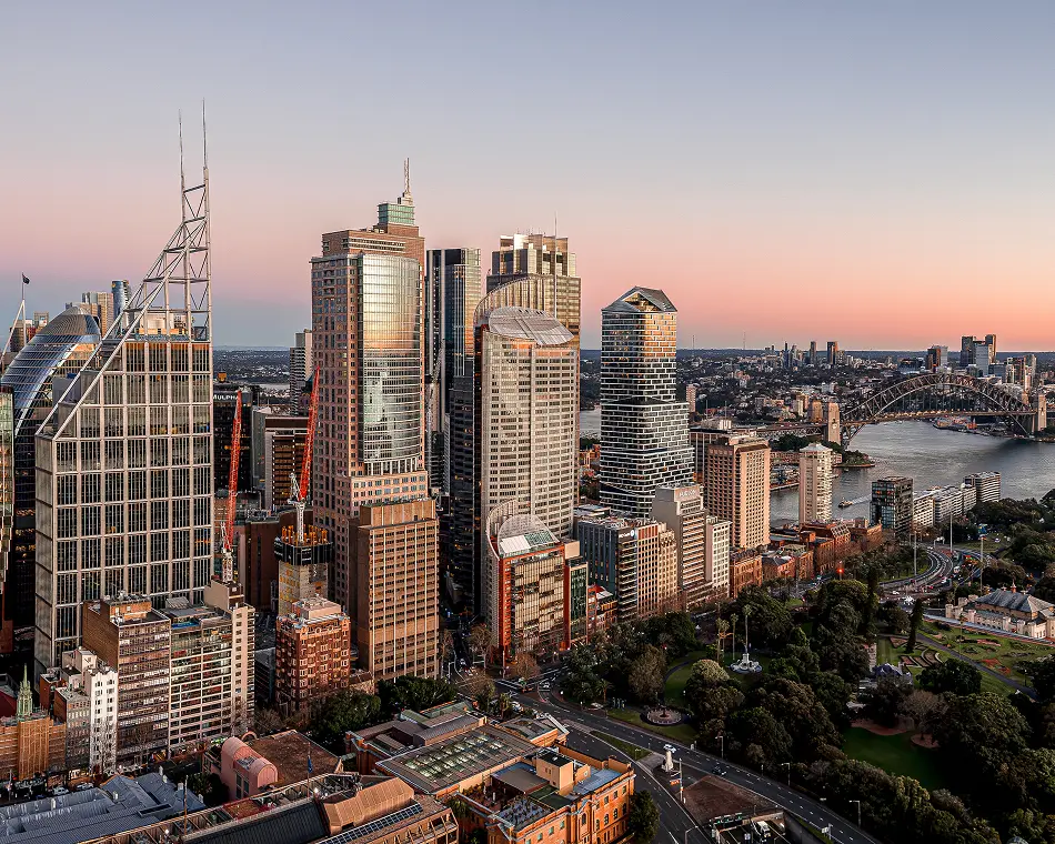 Aerial view of the Sydney CBD skyline at dusk, with the harbour and Harbour Bridge beyond
