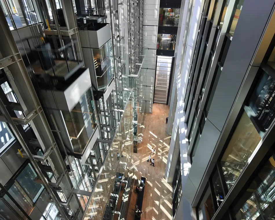 Looking down a glass-walled atrium with glass lifts at 126 Phillip Street